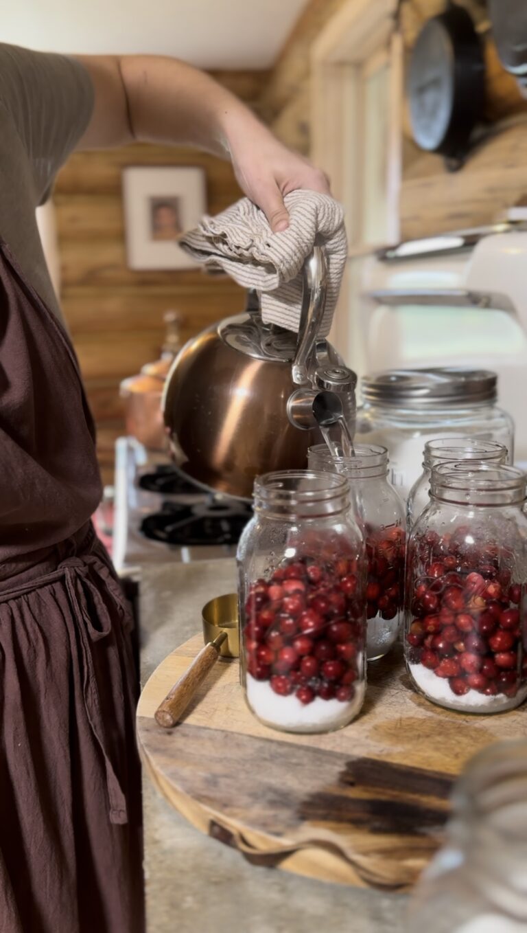 hot water pouring over cranberries in a mason jar
